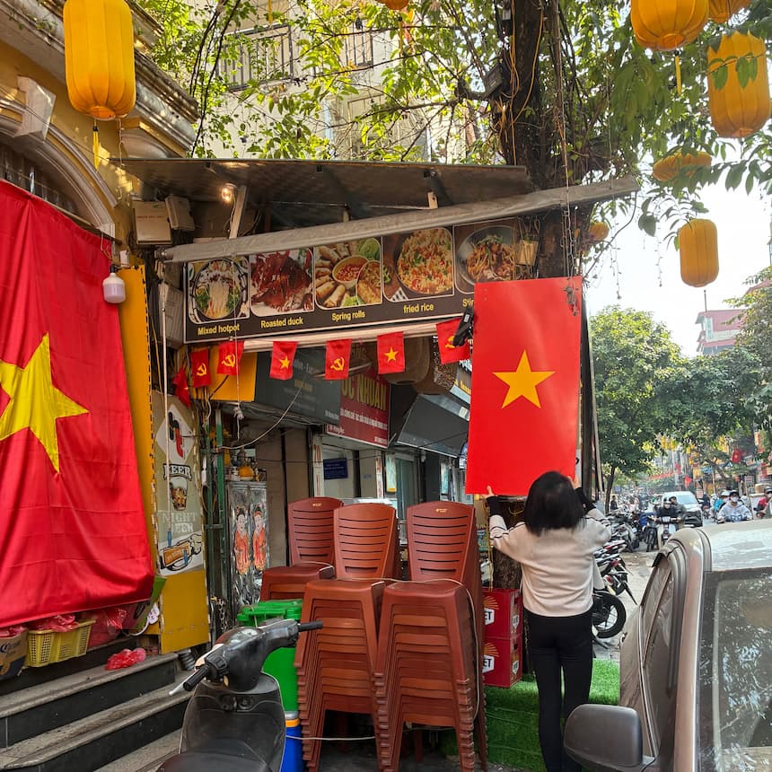 ハノイの食堂前で国旗と共産党旗が並んで掲げられている日常風景