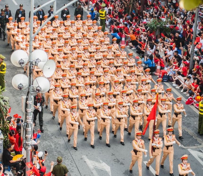 ベトナム独立記念日の軍事パレードで国旗を振る市民たち