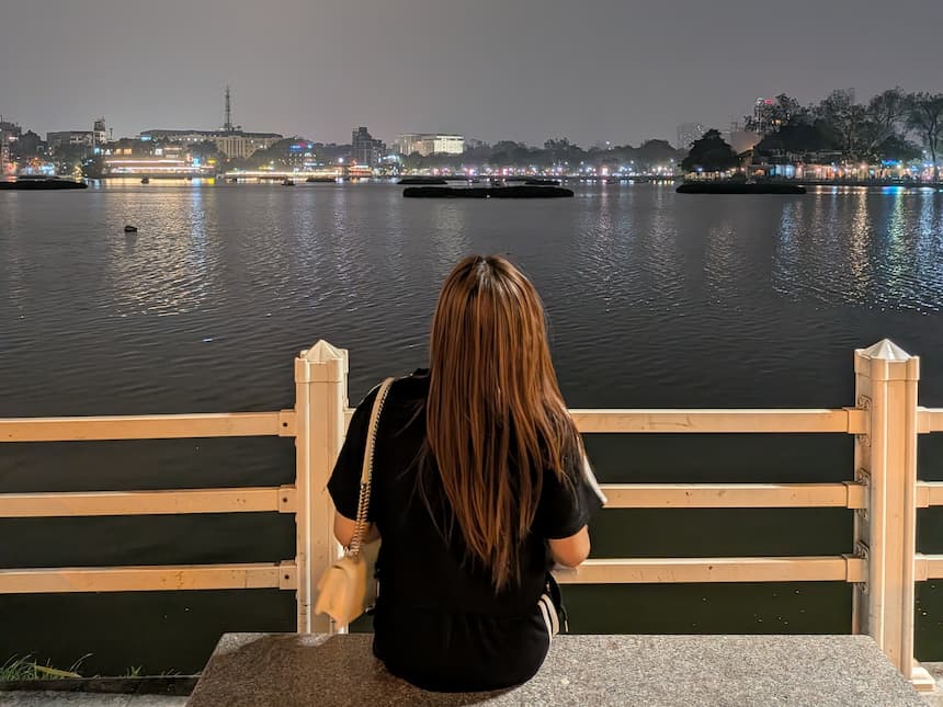 西湖の湖畔を眺める女性