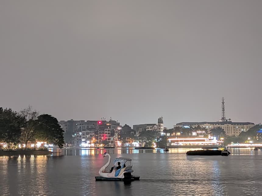 ハノイ・西湖（ホータイ）の夜景とスワンボート。湖面に街の灯りが映り、地元の人々の憩いの場としての雰囲気が伝わる一枚