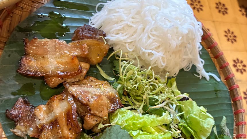 ハノイのブンチャー(炭火焼き豚肉・米麺ブン・生野菜がバナナの葉の上に盛られた一皿)