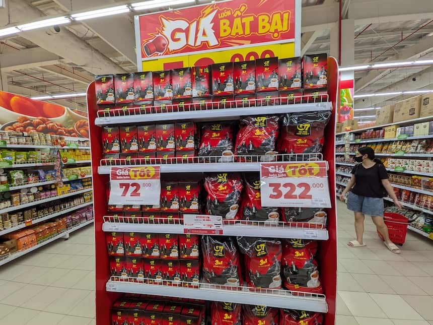 Alt Text: スーパーマーケットで販売されているベトナムの人気コーヒー「G7」の陳列棚。「ベストプライス（Giá tốt）」の掲示がされた、お得な価格で並ぶインスタントコーヒーの様子。