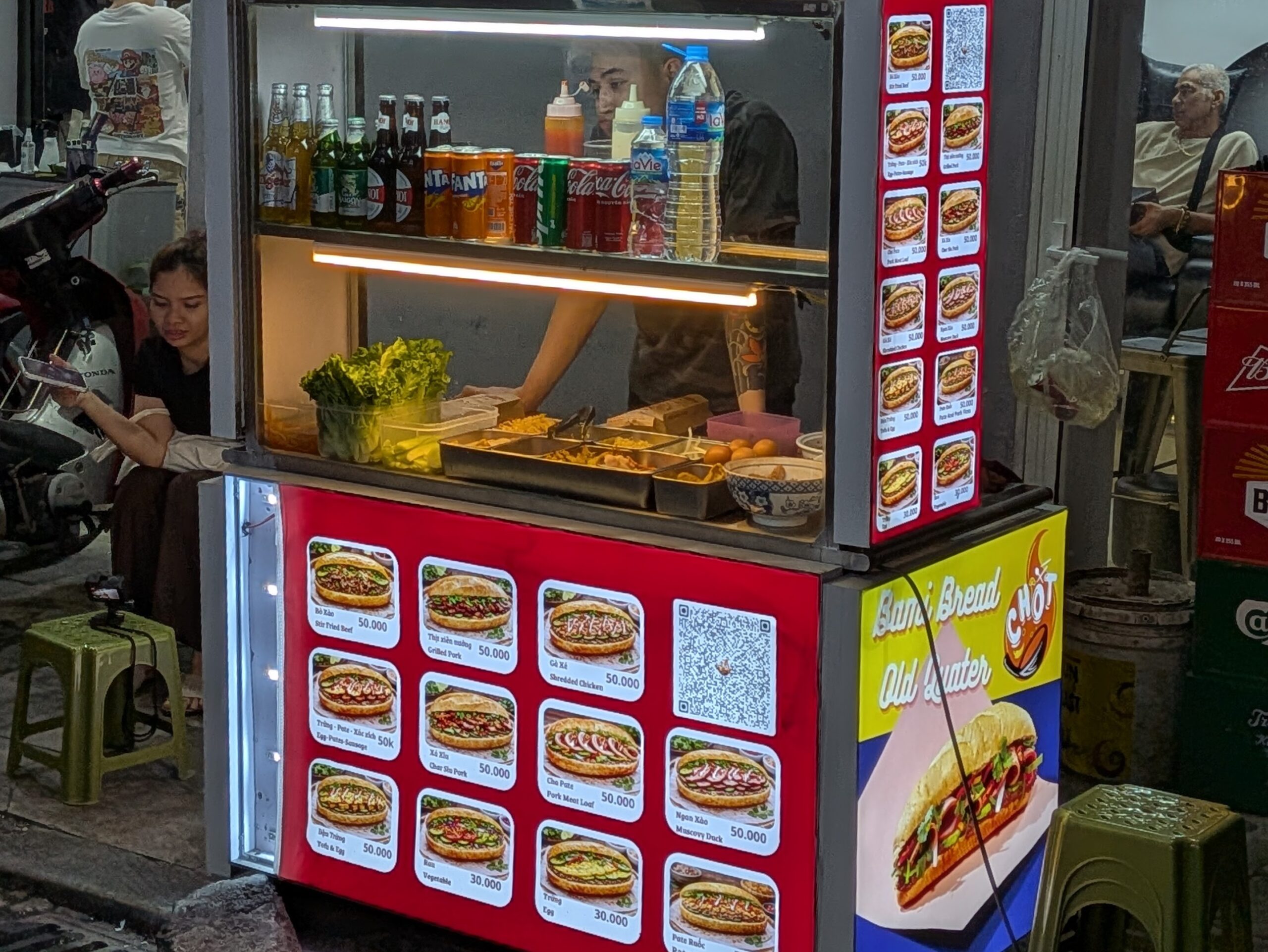 ハノイのバインミー屋台のメニューと具材が並ぶショーケース
