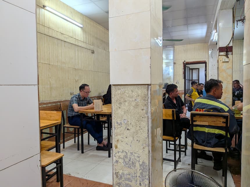 ハノイのビアホイ屋の店内で仕事帰りにビールを飲む地元客