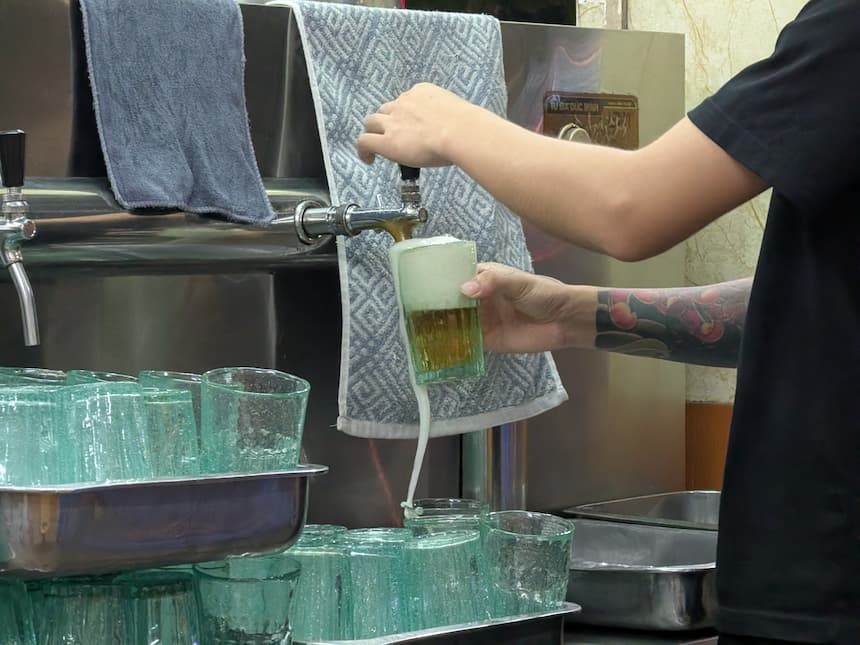 ビアホイのタップからグラスに生ビールを注ぐ瞬間（泡が溢れている）