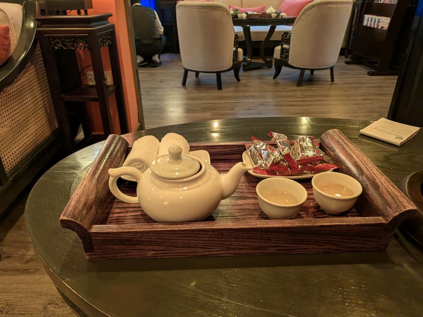 ウェルカムティーとピーナッツ菓子、温かいおしぼり