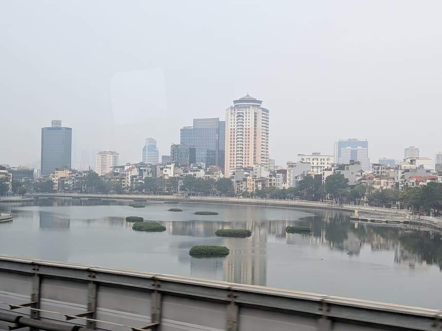 2A号線の高架から見えるハノイの街並みと湖。通勤路線らしい郊外の風景が広がる