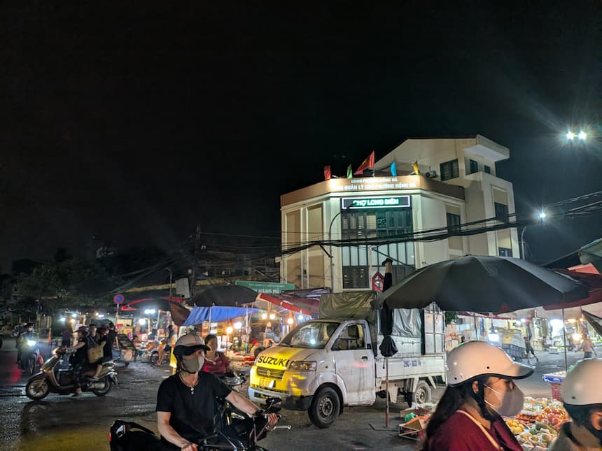 ロンビエン市場 夜の全景 バイクとトラックが行き交う青果卸売市場の活気ある風景