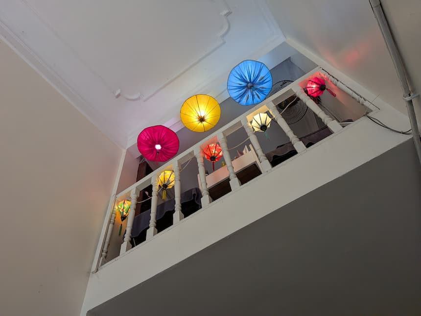 旧市街ローカル店の内装。2階部分に吊るされたカラフルなシルクランタンが旧市街らしい雰囲気を演出する