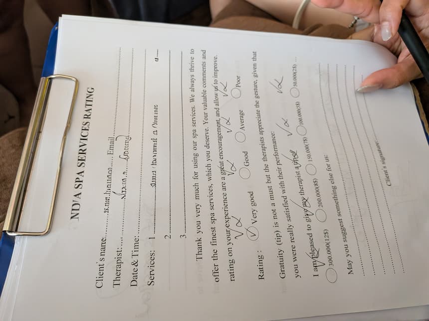 旧市街ローカル店のレーティング用紙。施術後に50,000〜300,000 VNDの範囲でチップ金額を選ばされる