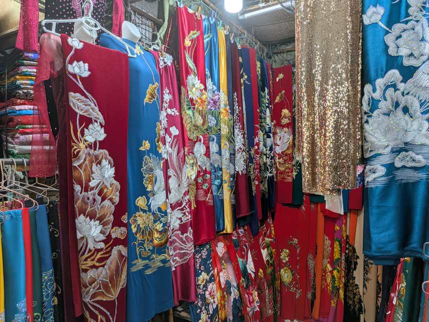 ベトナムの市場の衣料品店に、花や鳥の刺繍が施された色とりどりのアオザイがずらりと並ぶ。既製品はこうした市場や専門店で購入できる。
