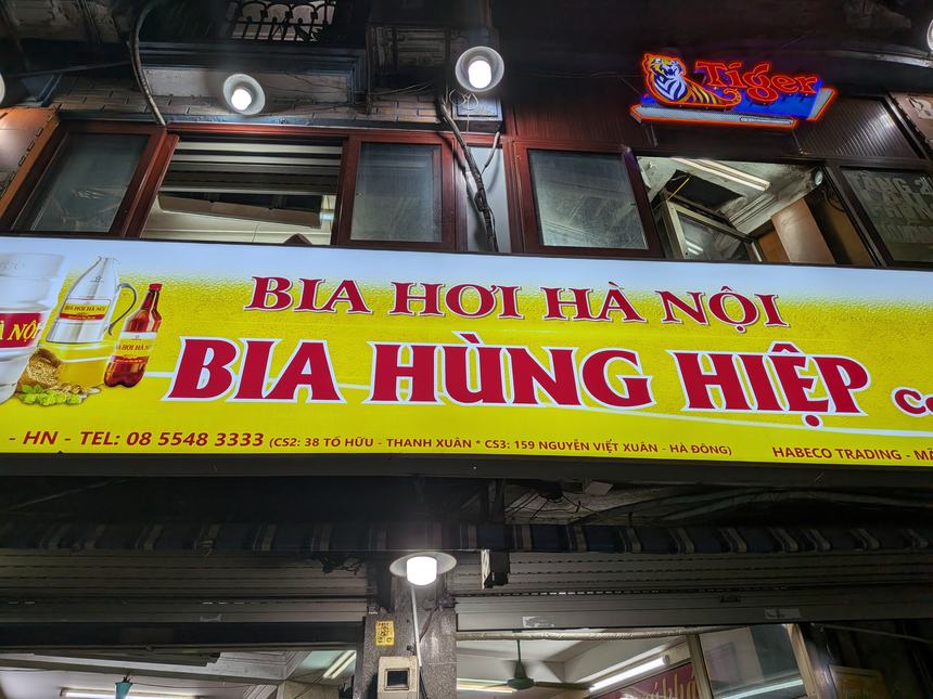 「BIA HƠI HÀ NỘI」と書かれた黄色地に赤文字の看板(ハノイのローカル・ビアホイ店)