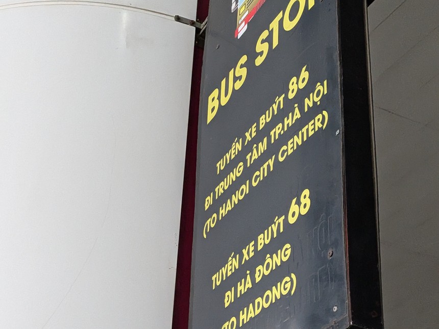 「BUS STOP:86(ハノイ市内中心部行き)・68(ハドン行き)」と書かれたバス停の案内看板