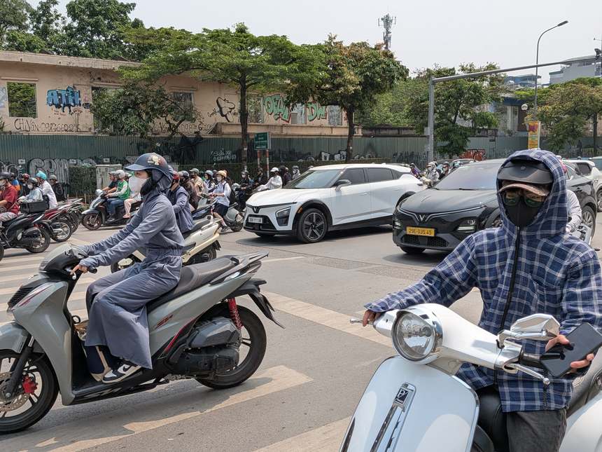 ベトナムの幹線道路を、マスクや日よけ装備をしたライダーたちがバイクで行き交う。排気ガスや粉塵の多い市街地ではマスクが欠かせない。