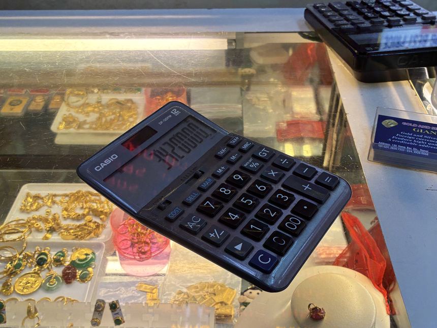 ベトナムの金行のショーケースに貼られた電卓。桁の多い金額のやり取りでは電卓が活躍する。日本円への換算は「ゼロを3つ取って×6」が手軽。