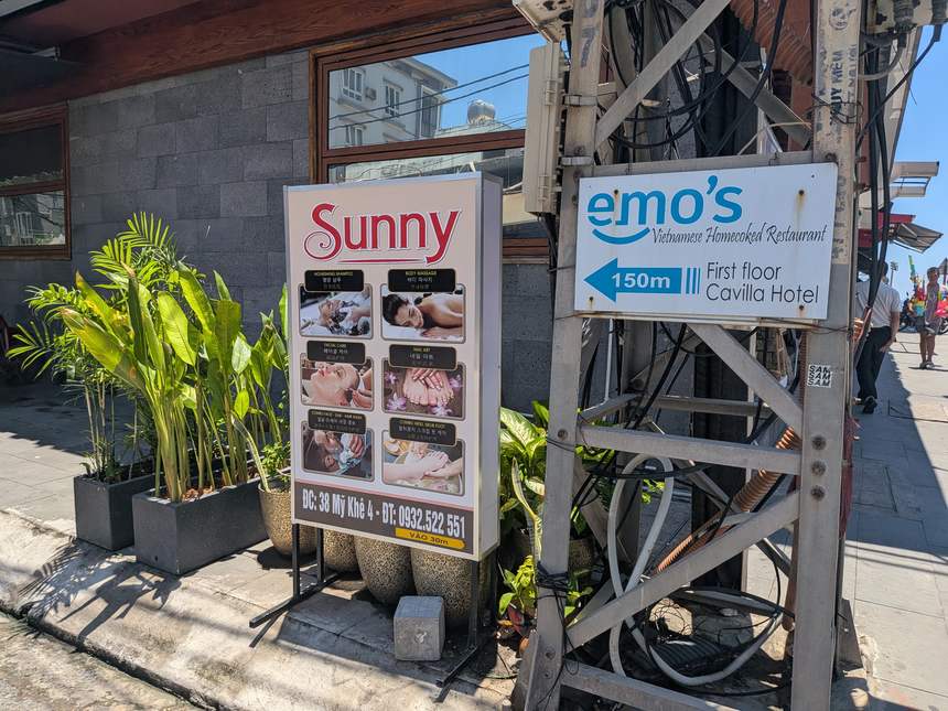ダナンのミーケビーチ近く、観光エリアに立つマッサージ店の店頭看板（日中）