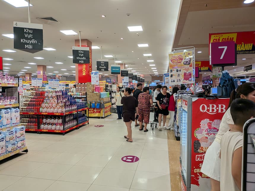 イオンモール・ロンビエン店1階のスーパー売り場のレジ付近｜特売エリアと日用品・食料品の棚