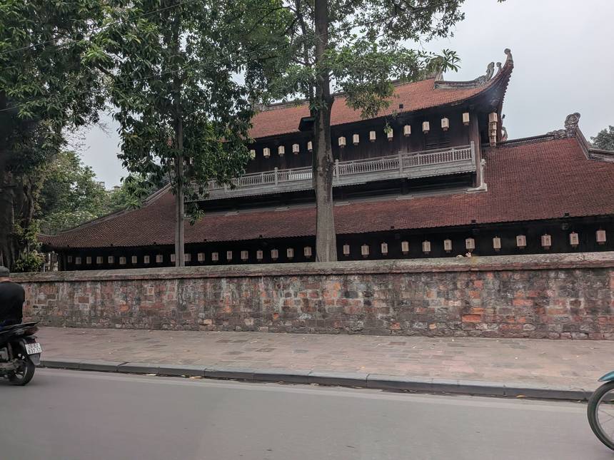 ハノイの文廟(孔子廟/Temple of Literature)。赤褐色の瓦屋根と木造の楼閣、レンガ塀が続く歴史的建造物。