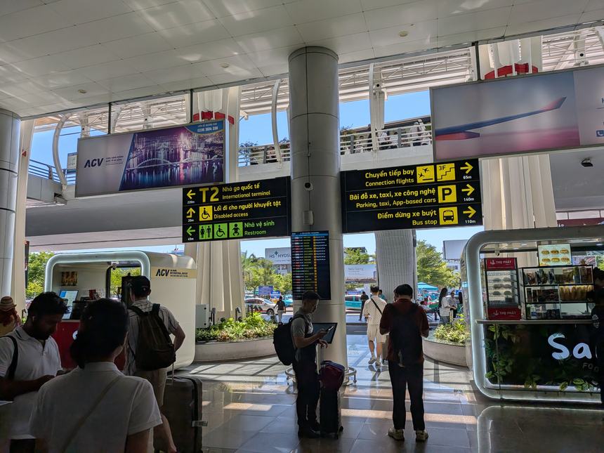 タンソンニャット国際空港T2の館内案内サイン。タクシー・配車(Grab)・バス乗り場・駐車場の方向表示