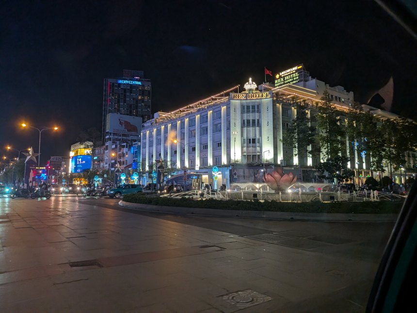 ホーチミン市中心部、夜間にライトアップされたレックスホテル(Rex Hotel)と周辺の繁華街。