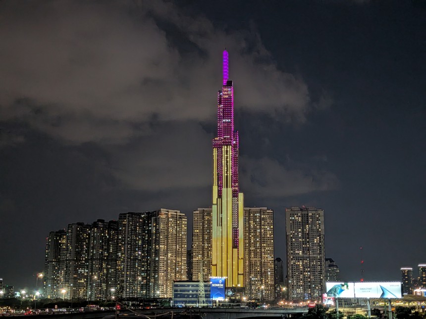 ベトナム・ホーチミン市のランドマーク81タワーが夜景に輝く様子。ピンク・パープルと金色のライトアップが施された超高層ビルが。