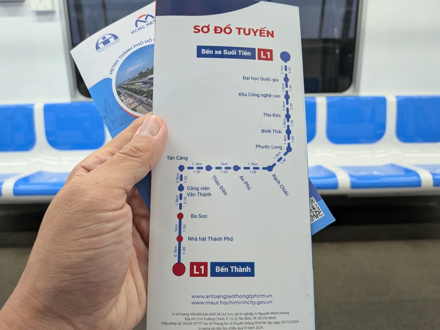 ホーチミン市メトロ1号線(L1)の路線図パンフレットを車内で手に持つ様子。ベンタイン駅からスオイティエン・バスターミナル駅までの全駅が記載されている。