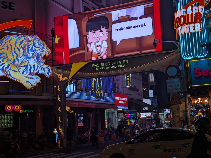 夜のブイビエン通り入口。同じ場所がネオンとバーの喧騒に一変する
