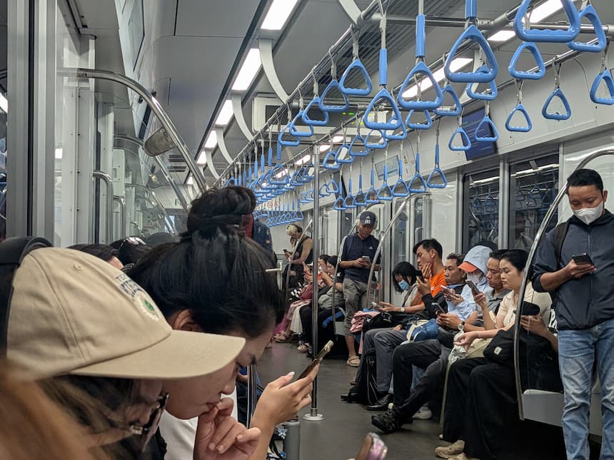 ホーチミン・メトロ1号線の車内。座席が埋まり立っている乗客もいるが、多くはスマホを見ている通勤客