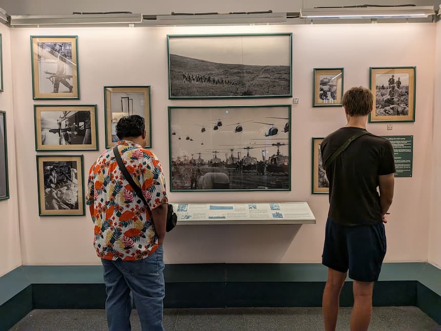 戦争証跡博物館で、壁に並ぶ戦争写真に見入る来場者たち