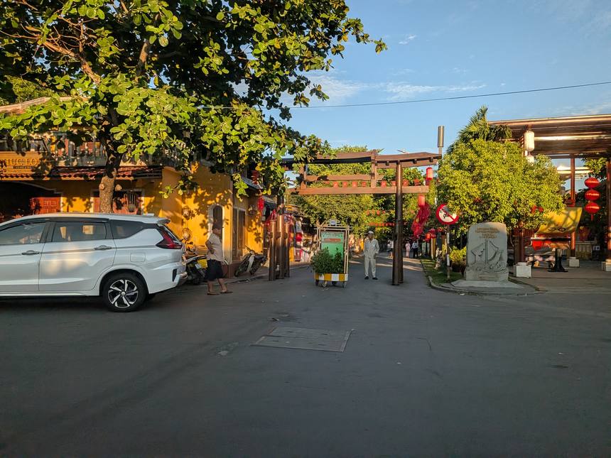 夕方の斜光に照らされたホイアン旧市街の通り。黄色い壁の建物と中国風の門が黄金色に輝く
