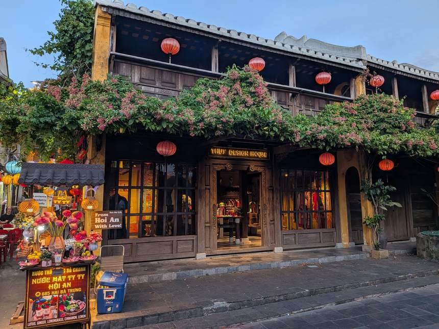 マジックアワーのホイアン旧市街。ブーゲンビリアと赤いランタンに彩られた木造の古民家ショップ