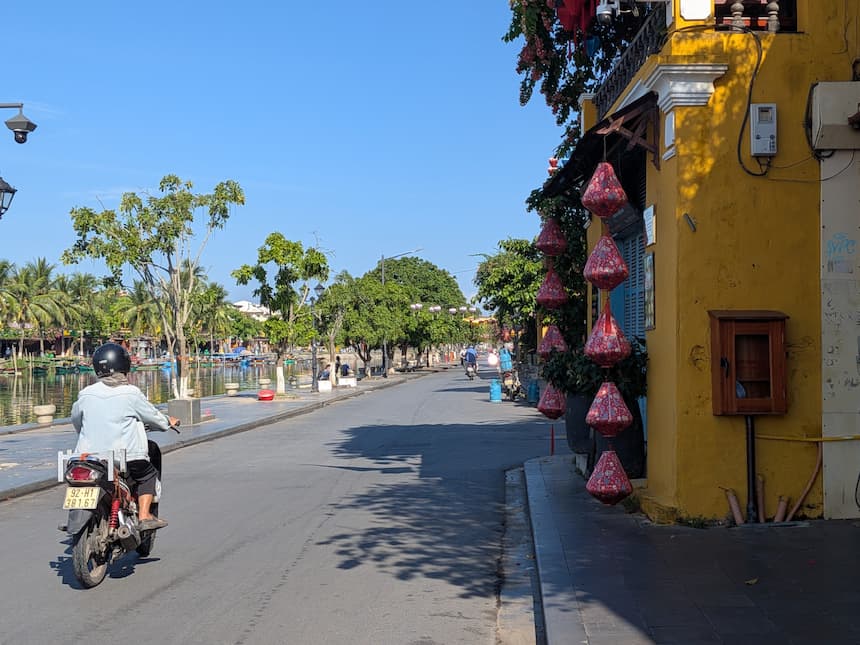 ホイアン旧市街バクダン通り(Bạch Đằng)沿いの黄色い壁の町家と赤いランタン、トゥボン川に浮かぶ手漕ぎボート