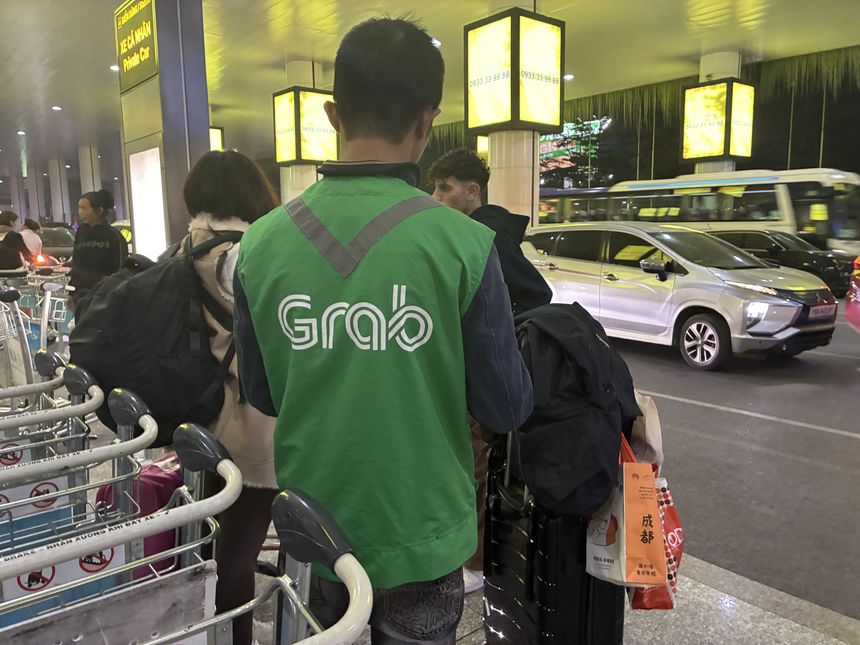 ノイバイ国際空港の到着エリアで配車を待つGrabのドライバー