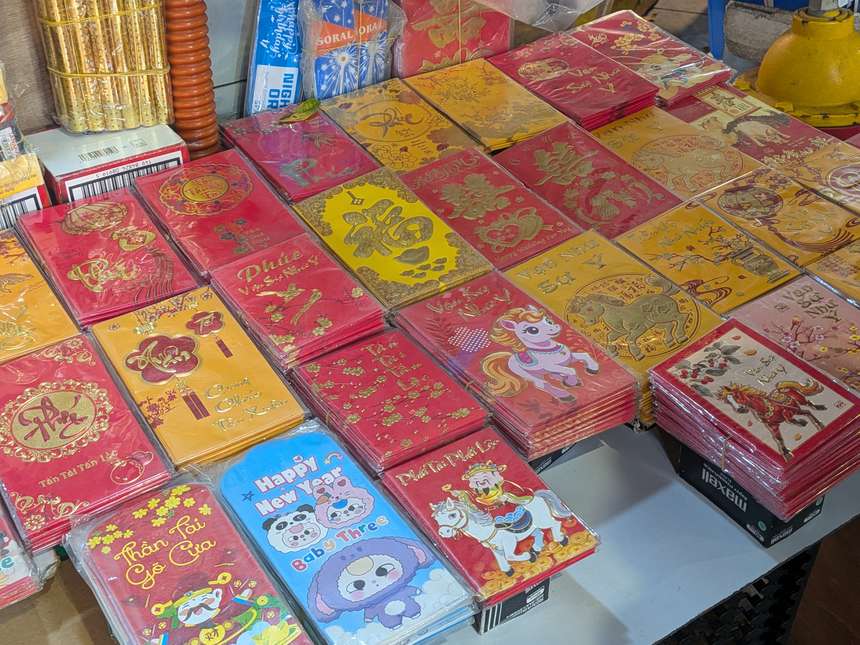 ベトナムの市場の露店に並ぶテト用のお年玉袋（バオリーシー）。赤や金箔模様の縁起のよいデザインがずらりと陳列されている。
