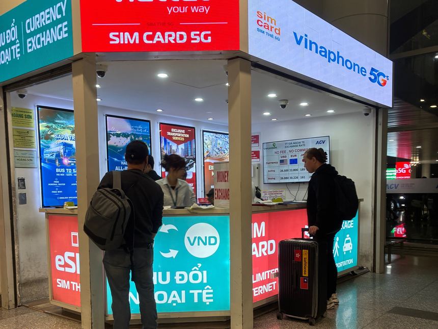 ベトナムの空港にあるViettelとVinaphone（5G対応）のSIMカード販売カウンター。旅行者がスタッフの対応を受けている。