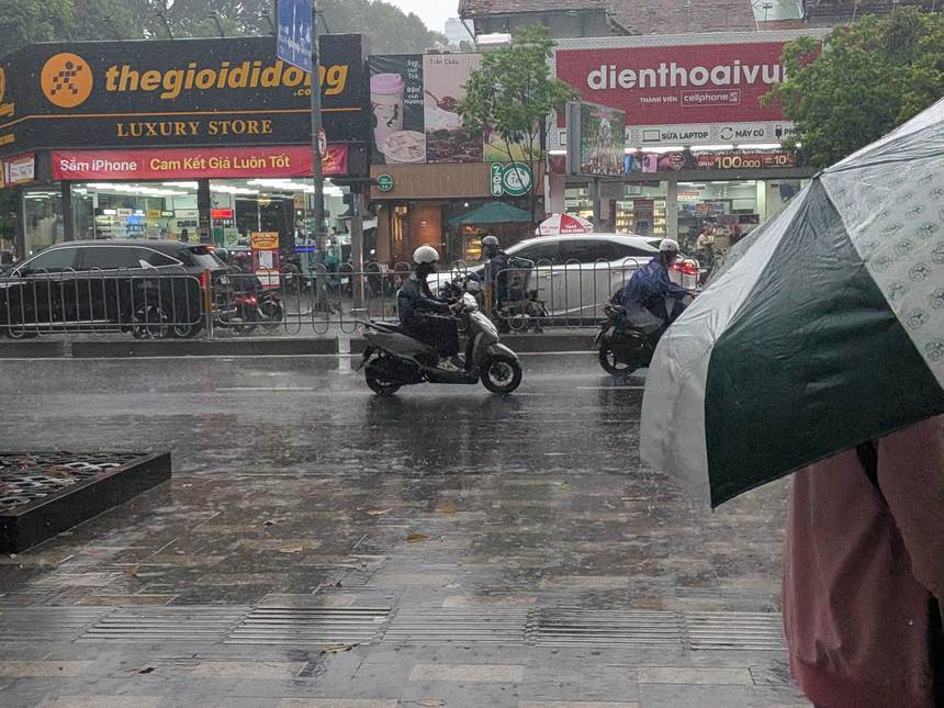 傘をさして歩く視点から見た、雨のベトナムの街角