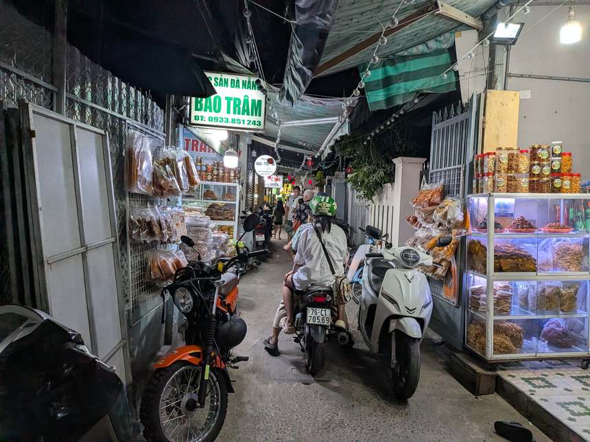 バインセオ バーユンへ続く路地の内部。両側に商店が並び、バイクが停められている