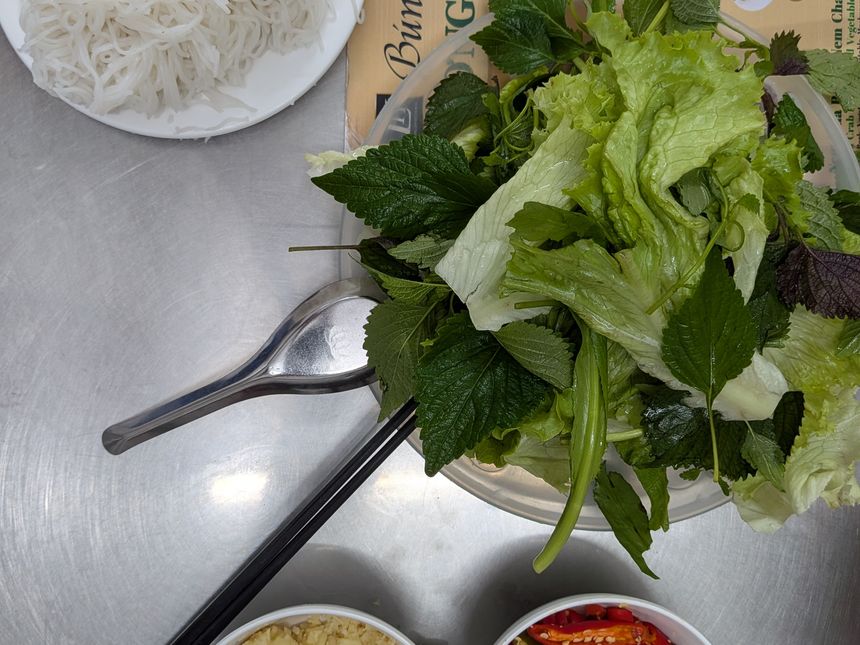 ブンチャーに添えられる生野菜の大皿。レタスや香草、にんにく・唐辛子