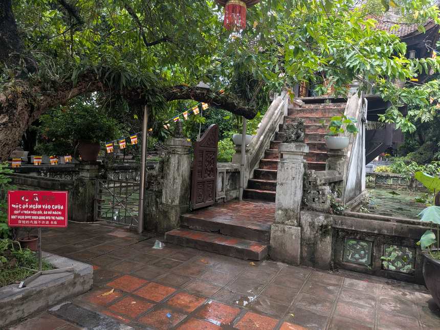 一柱寺の入口にある赤い掲示。「CẤM MẶC ĐỒ NGẮN VÀO CHÙA／DON'T WEAR SHORT…」と短パンでの入場を禁じている