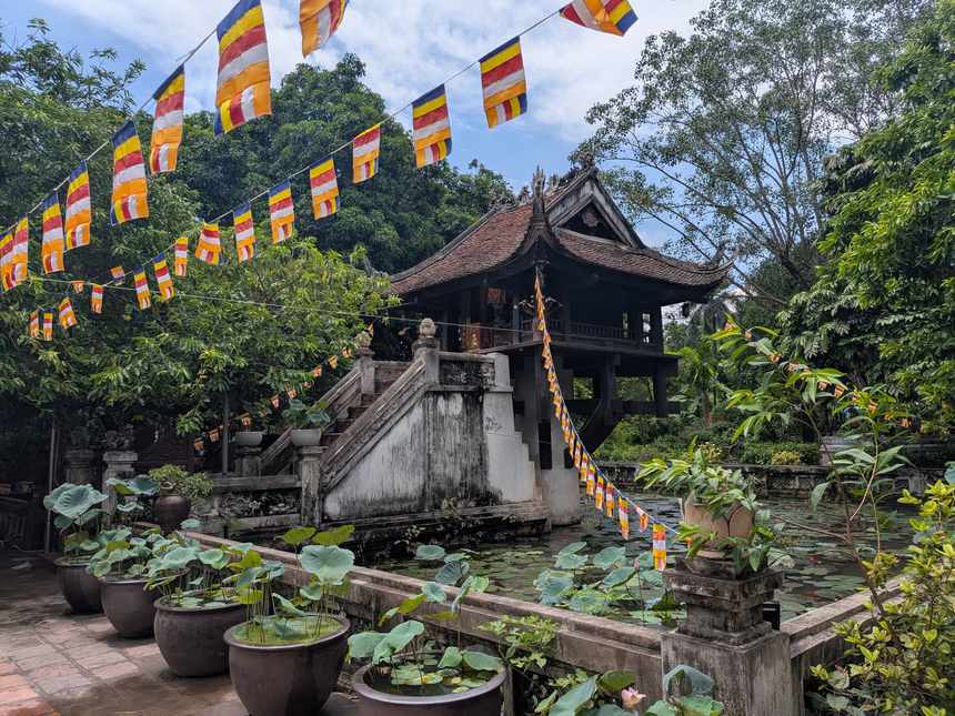 一柱寺の全景。蓮の池の上に1本の柱で支えられた小さなお堂が建ち、仏教旗が張り渡されている