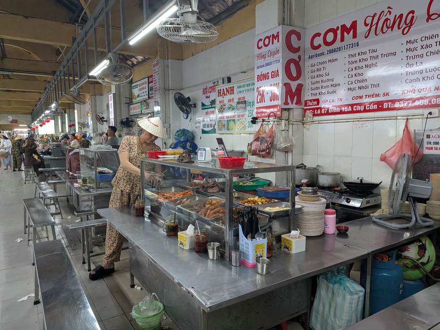コン市場のフードコートにある定食の屋台。ステンレスの台に総菜が並び、値段の看板が壁に貼られている