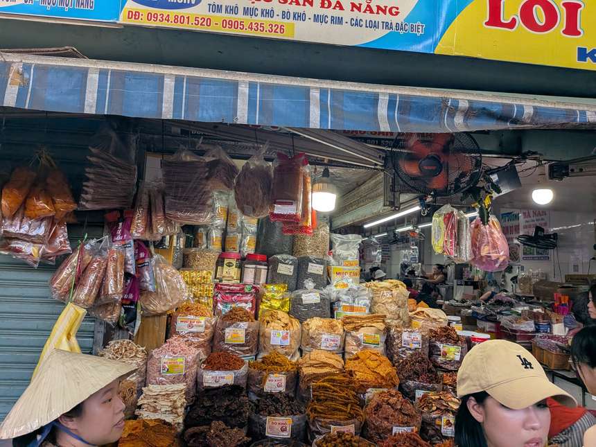 コン市場の乾物店。干しイカや牛肉のジャーキーが品名ラベル付きの袋で山積みになっている
