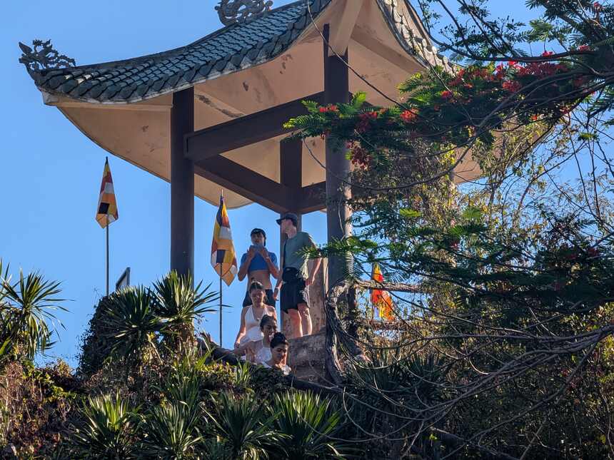 五行山の岩の上に立つ東屋。反り返った瓦屋根と仏旗