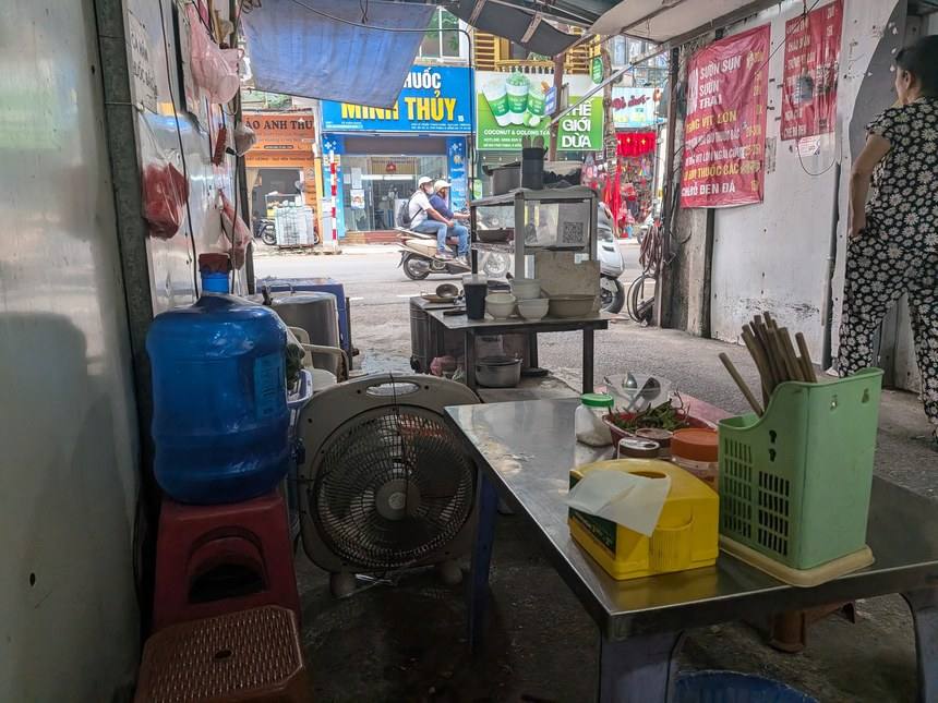 ハノイの路上に出ているホビロンの屋台。低いテーブルと椅子が並び、壁に赤い値段表が貼られている
