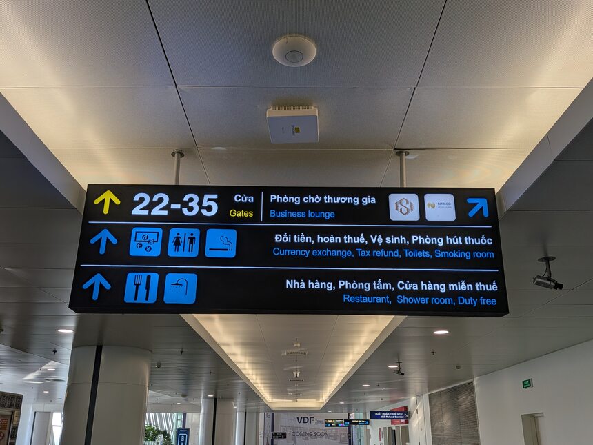 ノイバイ空港T2 3階の案内サイン。22〜35番ゲート方向とビジネスラウンジへの矢印が示されている