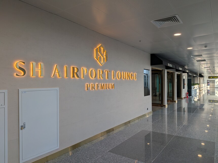 白い壁にSH AIRPORT LOUNGE PREMIUMの文字が掲げられた通路
