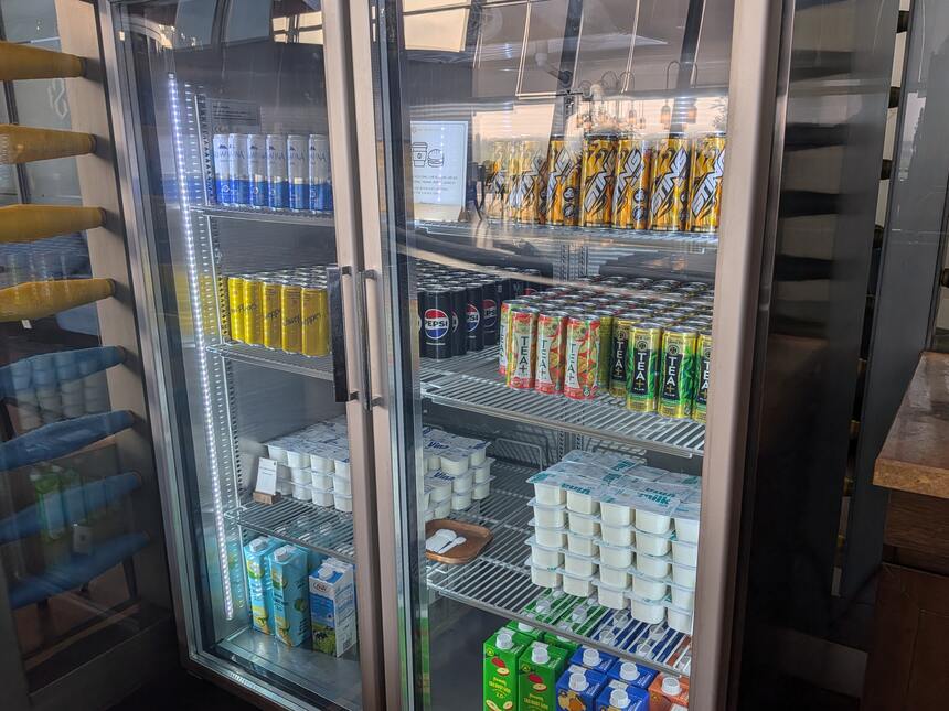ラウンジのドリンク冷蔵庫。ミネラルウォーターや炭酸飲料、ヨーグルトが並ぶ