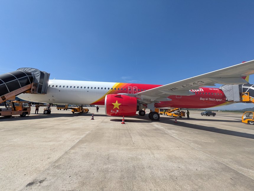空港のエプロンに駐機するベトジェットのエアバスA321（VN-A543）。機体にはBay là Thích ngay!のスローガンが描かれている。