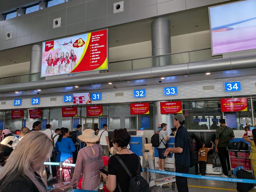 ダナン国際空港のベトジェットのチェックインカウンター（28〜34番）に並ぶ乗客。30番はONLINE CHECK-IN BAG DROP（オンラインチェックイン専用の手荷物預けカウンター）。