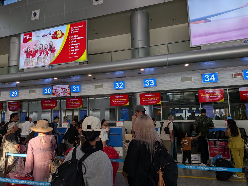 ダナン国際空港のベトジェットのチェックインカウンター29〜34番。どのカウンターにも全便共通のチェックインの表示が出て、乗客が列をつくっている。
